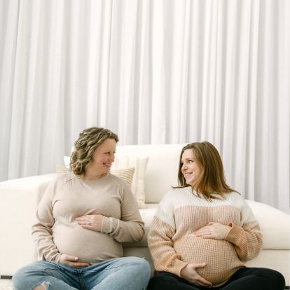 Two pregnant women sit side by side