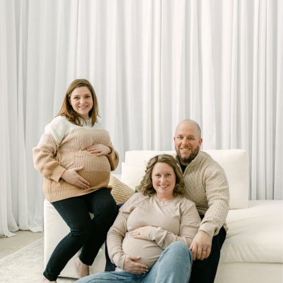 a married couple sit beside their surrogate mother