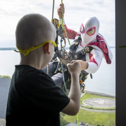 Elite Window Washing Superhero Image of a superhero window washer with child at window