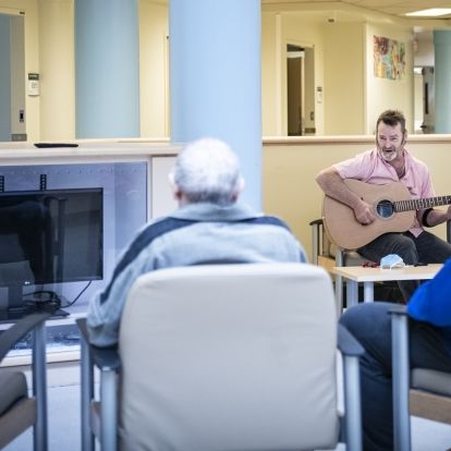A guitarist plays for patients.