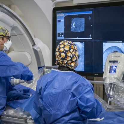 A physician and a nurse look at a screen during a procedure.