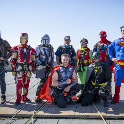 a group of superheroes stand on the roof of Kingston General Hospital