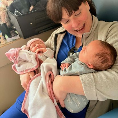 a labour and delivery nurse holds two young babies