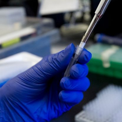 a hand holding and filling a vile