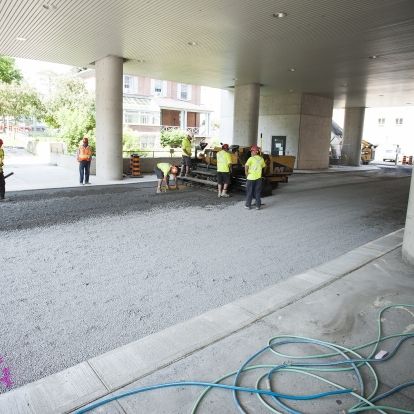 Construction crews prepare to lay asphalt under the front canopy.
