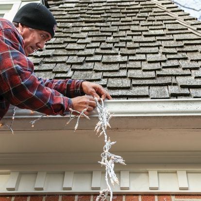 man hanging Christmas lights