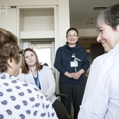 Members of the care team sit and talk with a patient about their plans for discharge.