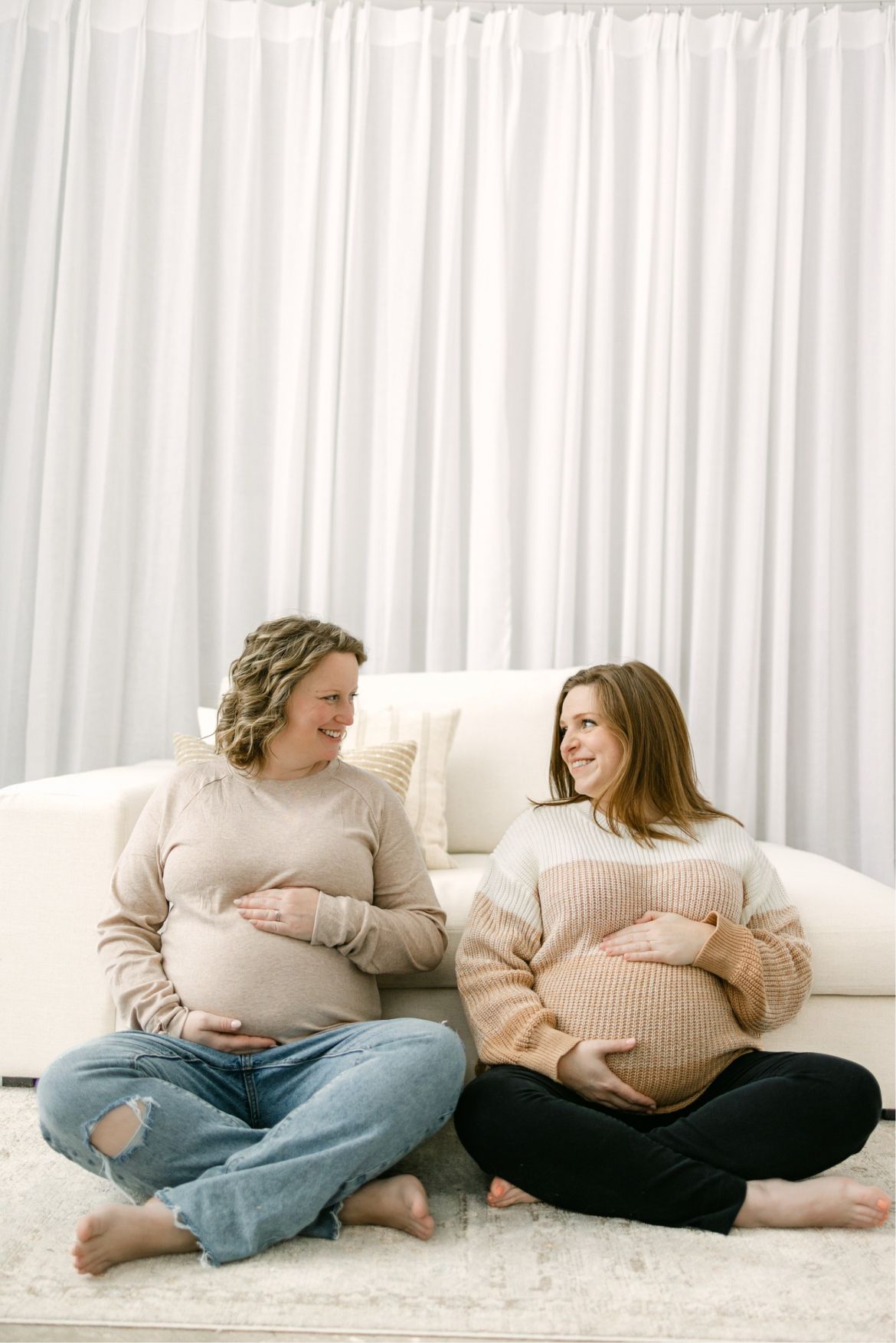 Two pregnant women sit side by side