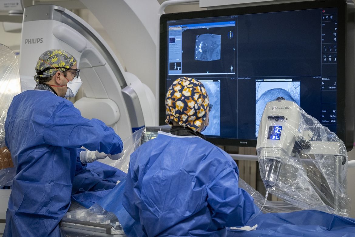 A physician and a nurse look at a screen during a procedure.