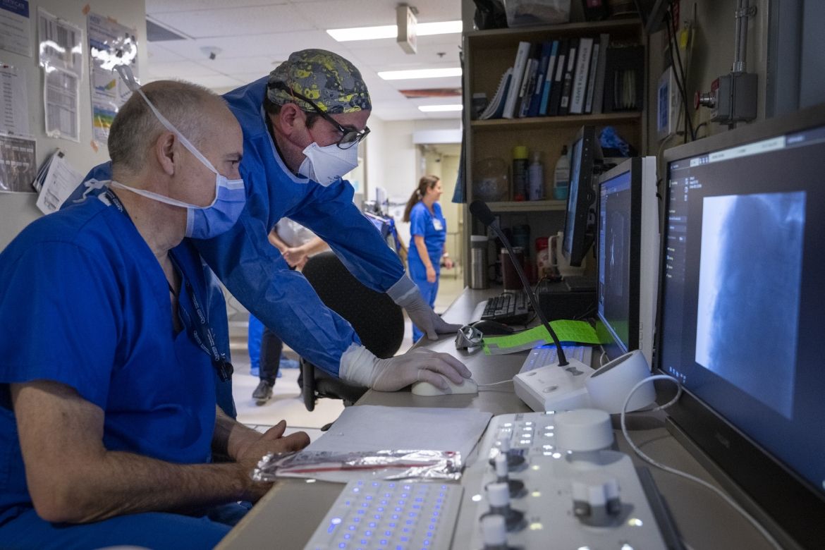 A physician and a medical radiation technologist in the IVR control room