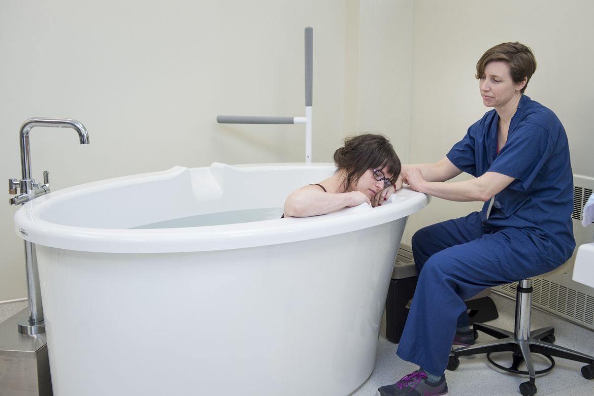 A patient demonstrates how the tubs will be used under the supervision of a registered midwife.