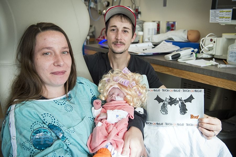 Mom and Dad with their new baby who is dressed up for Halloween