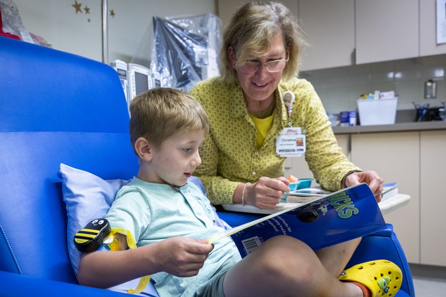 Child Life staff reading a book to a young patient
