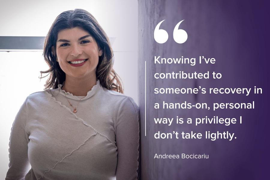 PeopleOfKHSC_Andreea_Bocicariu_9 Andreea Bocicariu is standing against a wall and smiling directly into the camera. She has brown wavy hair, brown eyes and is wearing a white blouse with a gold heart necklace.