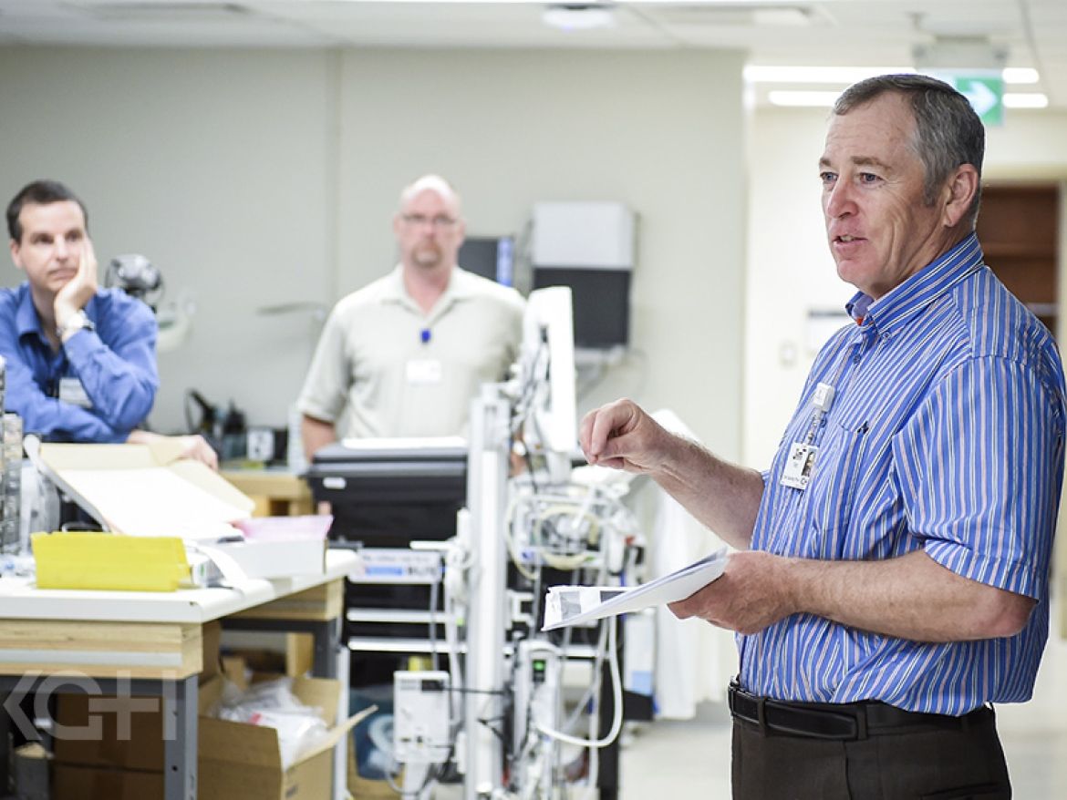 CEO Jim Flett speaking with staff in their work spaces.
