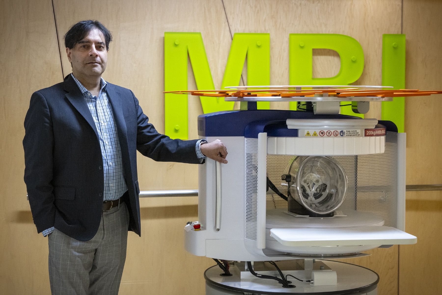 Dr. Omar Islam stands next to the Swoop Portable MRI