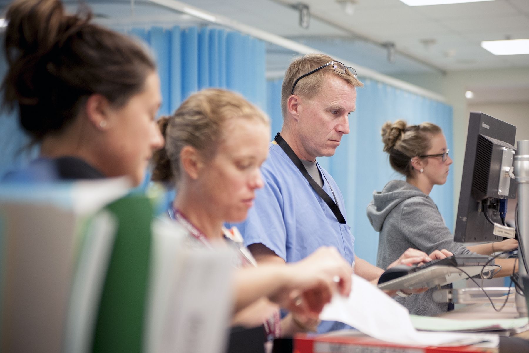 Physician Dr. Paul Dungey (centre) jumps on a computer in the KGH Emergency department to do some electronic charting.