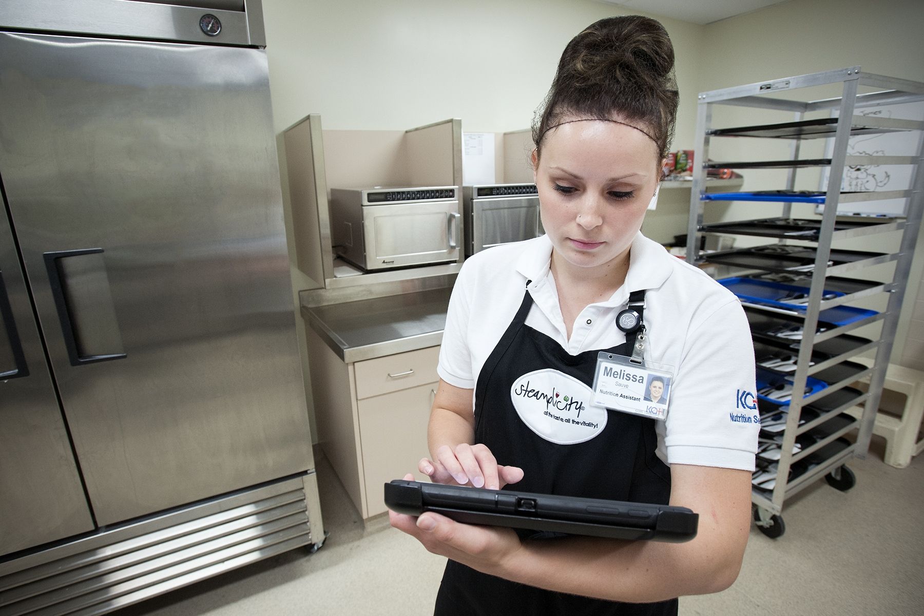 Nutrition Assistant Melissa Sauve prepares meals for patient's on Davies 5 using a new hand-held tablet that helps her build the patient's meal order.