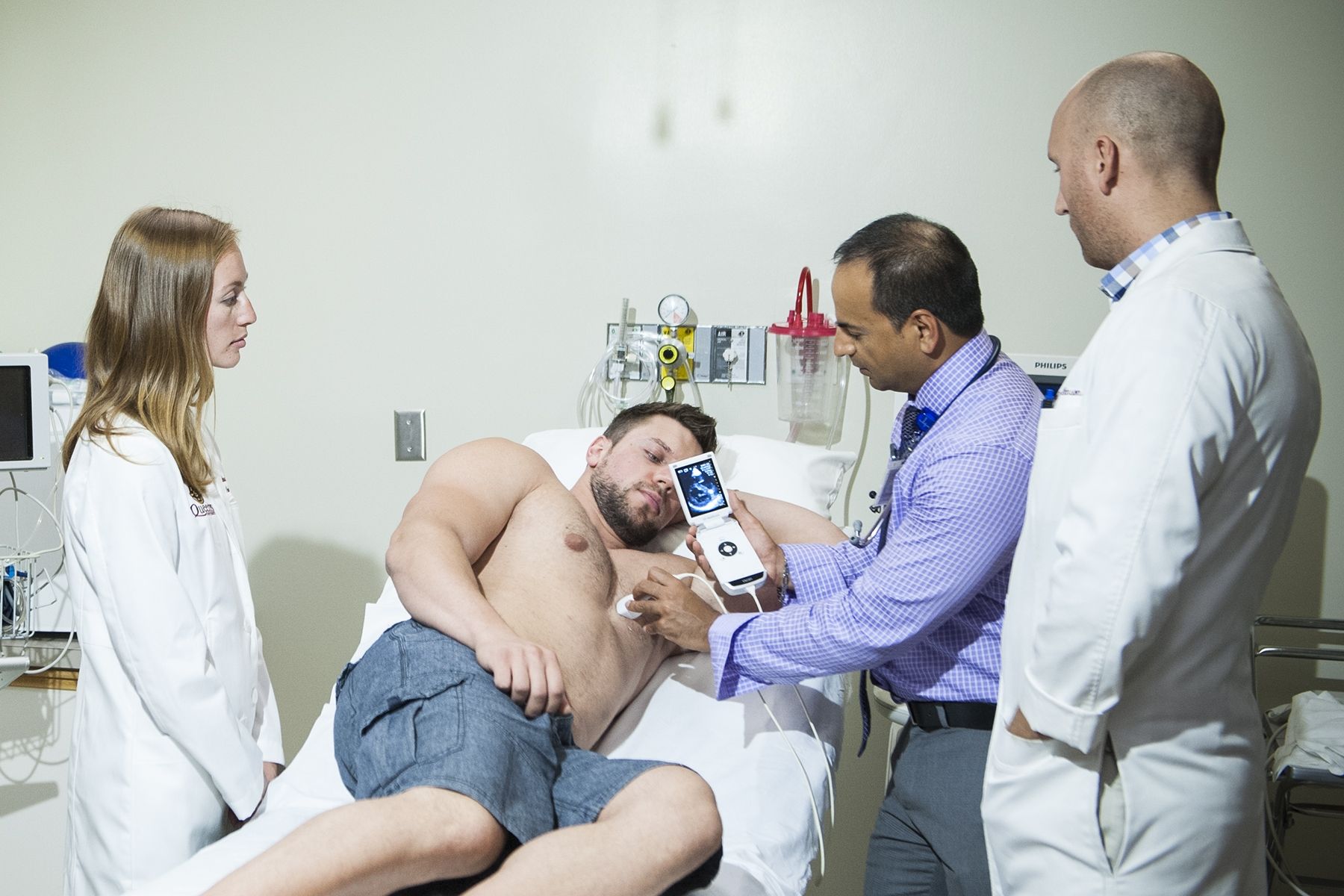 Dr Amer Johri of the KGH Research Institute emonstrates the use of a portable hand-held ultrasound at a patient's bedside.