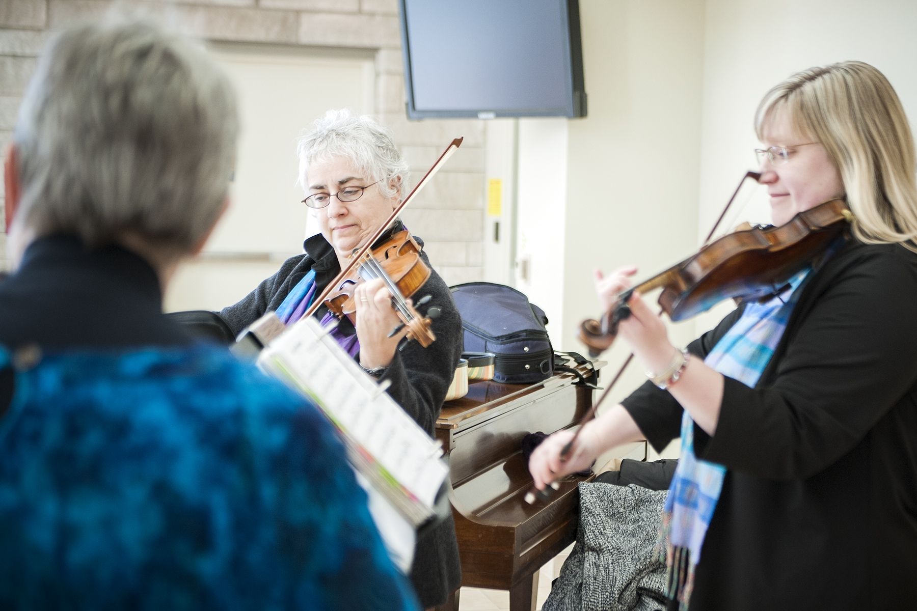 Members of the Triola Trio, Gisele Dalbec Szczesniak (centre), Melinda Raymond (right) and Eileen Beaudette (left) entertained listeners in the Burr lobby with their version of Journey's hit "Don't Stop Believin."