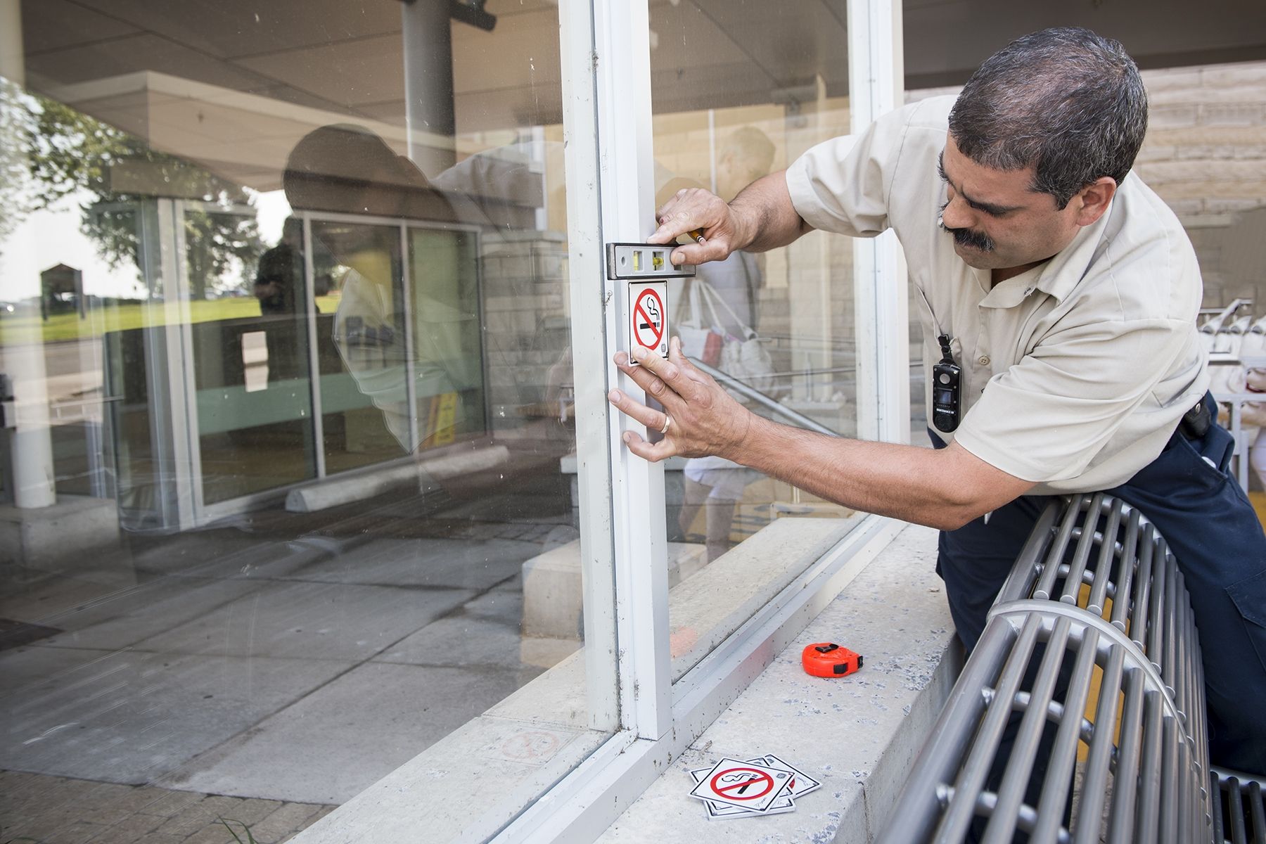 Dave De Sousa measuring up areas outside of the Burr wing where some new non-smoking signs are going to be installed.
