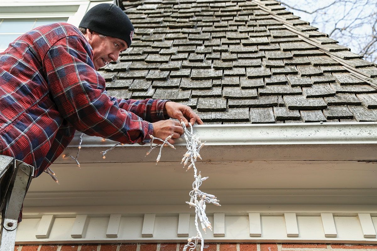 man hanging Christmas lights