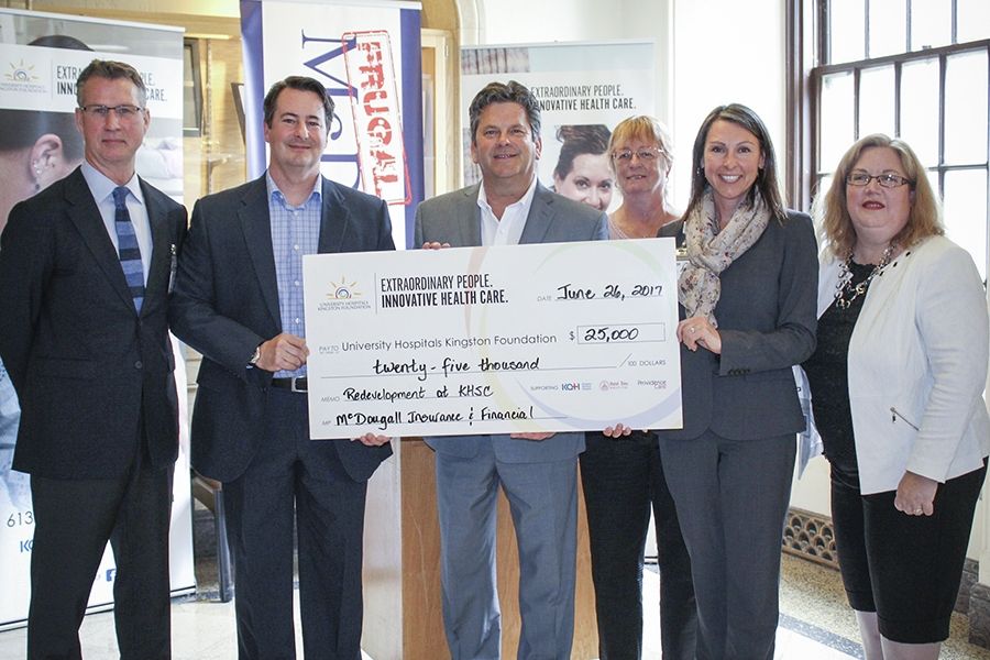 KHSC Board Chair David O'Toole (left) and UHKF staff (right) accept a donation from MacDougall Insurance and Finance (centre)