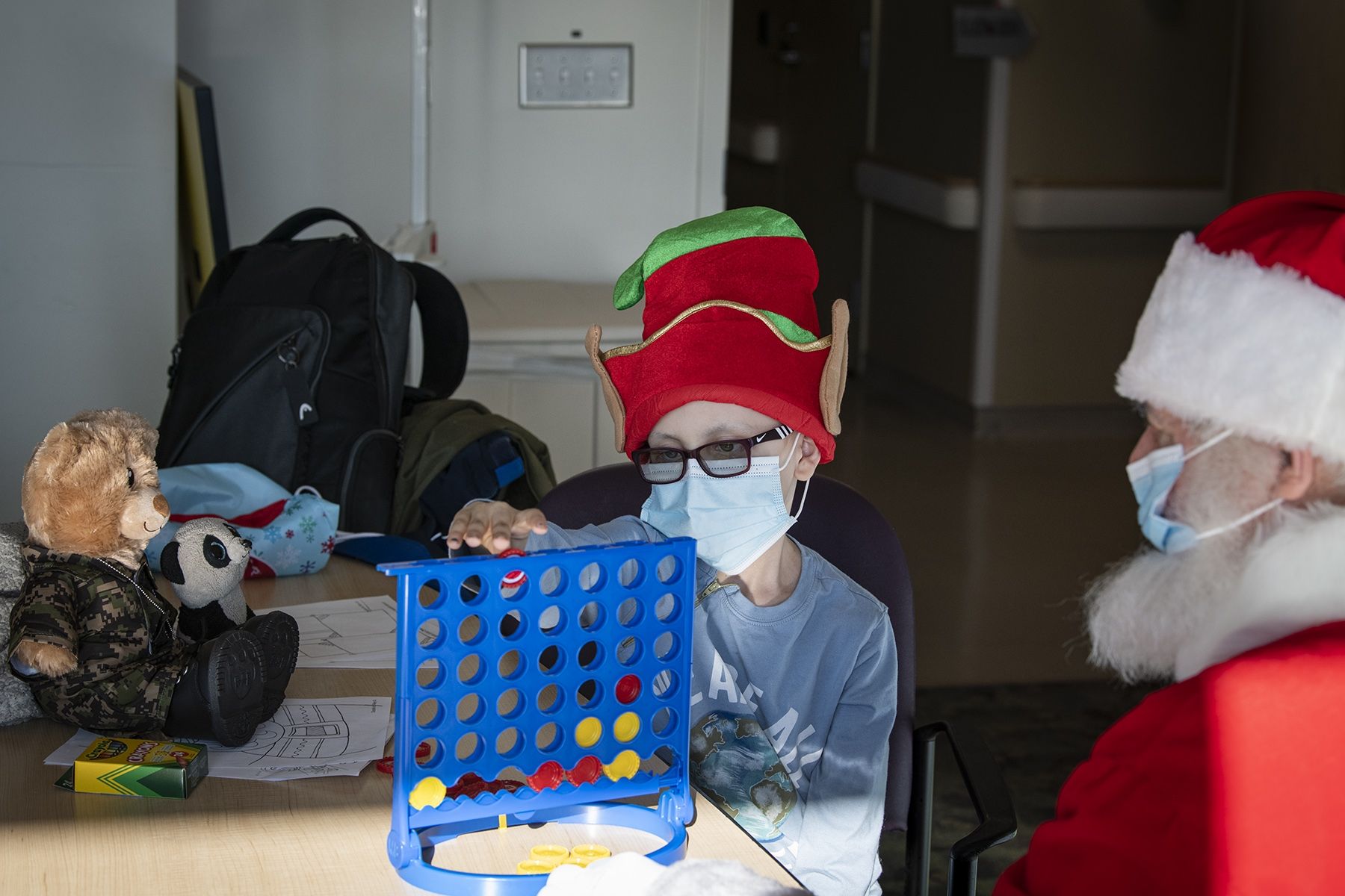 Santa stops for a game of Connect 4 with one of our pediatric patients