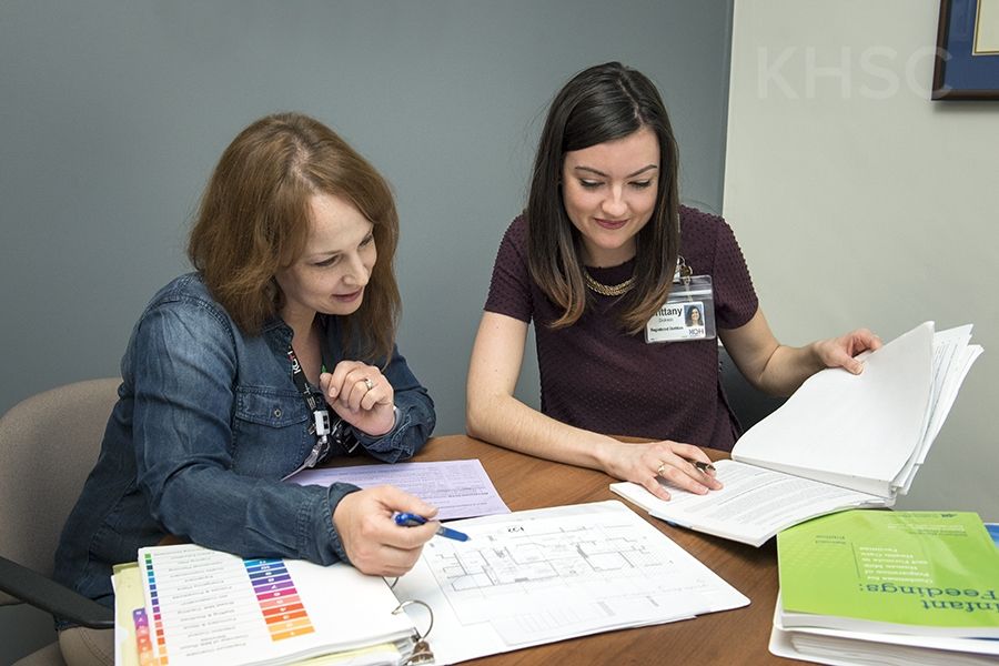 Angela Hollett, left, and her colleague Brittany examine plans for a future milk-prep room at KHSC.