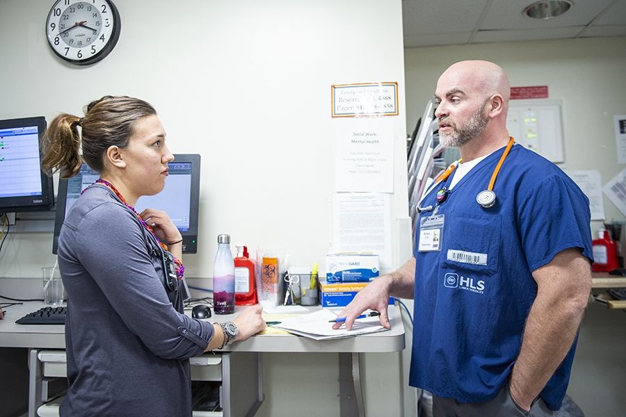 In his pilot role as Mental Health Nurse Navigator in the ED, Richard Cook, right, works closely with Social Worker Sarina Cormier, left, and other members of the ED team to speed up treatment and reduce wait times for patients with mental health emergencies.