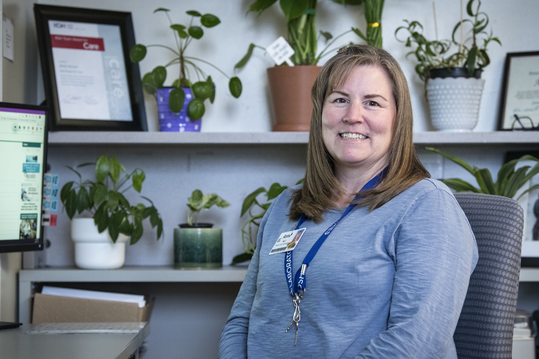 Anne Vincent is pictured inside her office at KHSC's Kingston General Hospital site. She has shoulder length, brown hair and is wearing a blue, long-sleeved shirt.