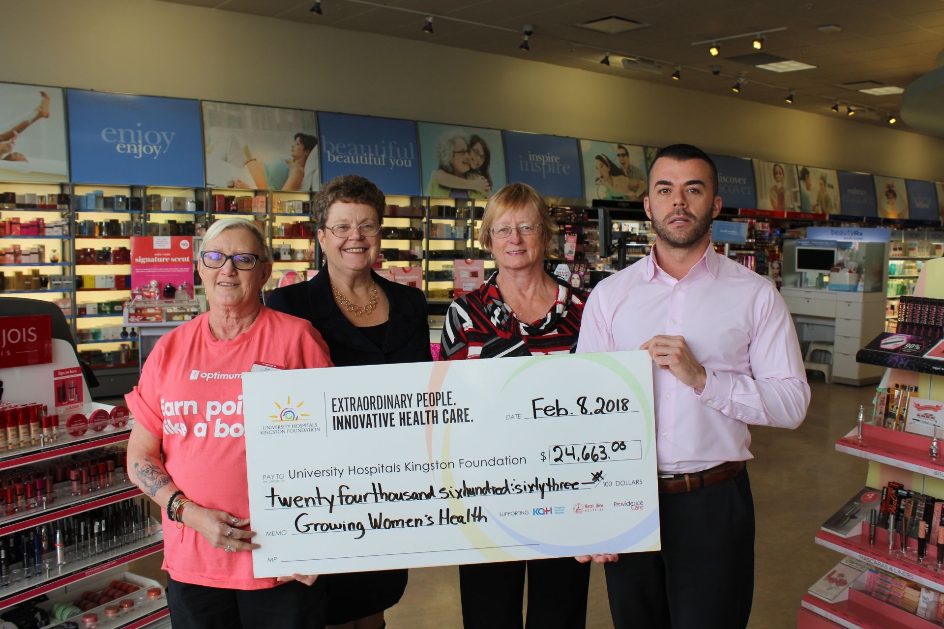 Staff from Shoppers Drug Mart present a cheque to representatives from the UHKF